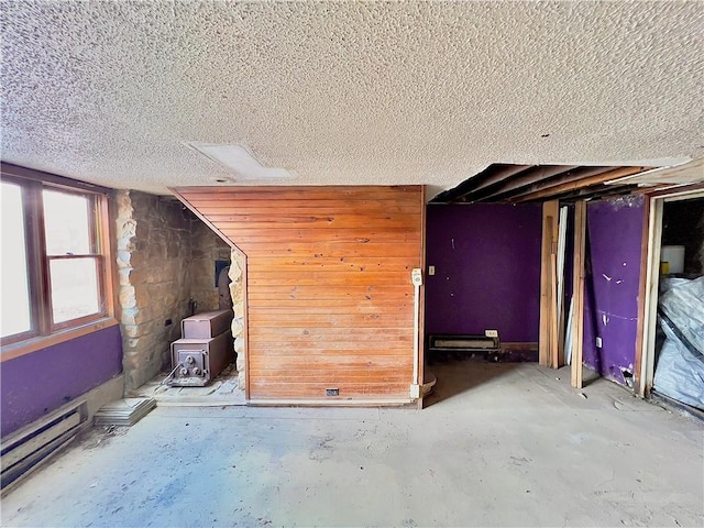 8401 E Lake View Dr, Freeman, MO 64746 - misc room with a textured ceiling, a wood stove, and unfinished concrete flooring