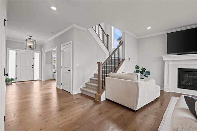 living room featuring ornamental molding, hardwood / wood-style floors, and a notable chandelier