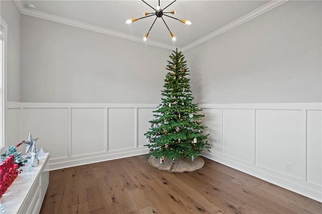 unfurnished room with wood-type flooring, ornamental molding, and a chandelier