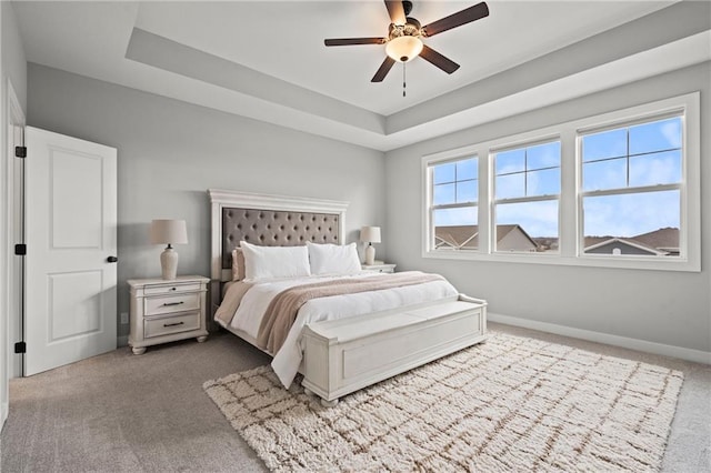 bedroom with a tray ceiling, carpet floors, and ceiling fan