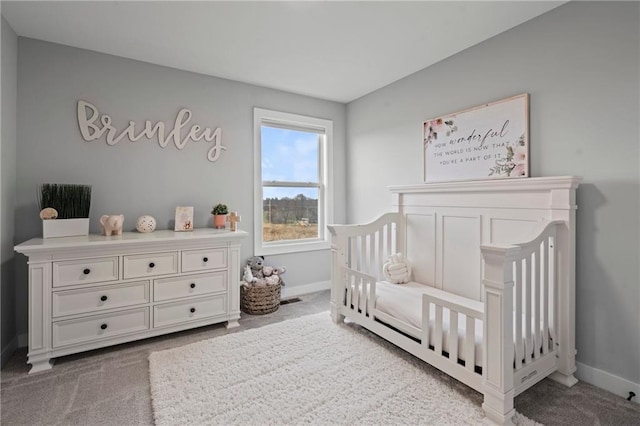 bedroom with a nursery area and carpet