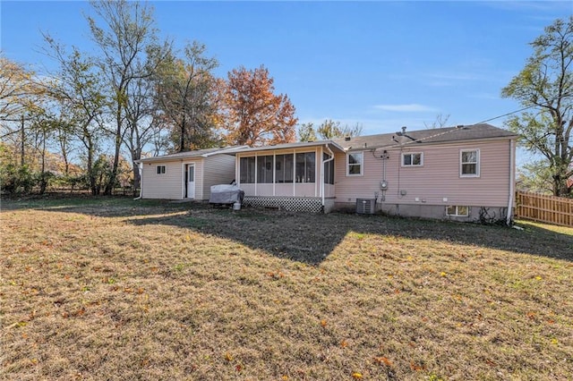 rear view of house featuring a sunroom, a yard, and cooling unit