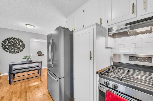 kitchen with white cabinets, a textured ceiling, stainless steel appliances, and light hardwood / wood-style flooring