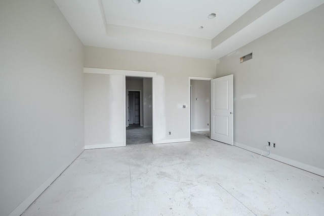 unfurnished bedroom with a raised ceiling