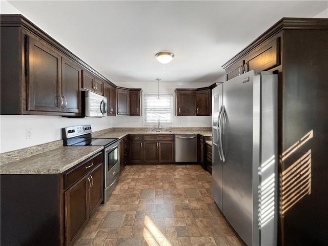 kitchen with stainless steel appliances, dark brown cabinetry, decorative light fixtures, and sink