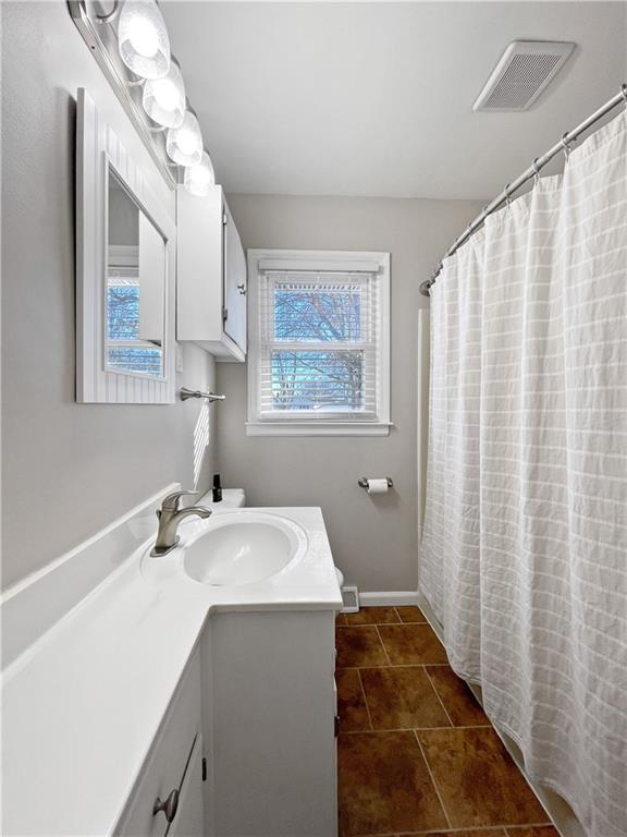 bathroom featuring walk in shower, vanity, and tile patterned flooring