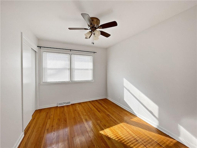 empty room featuring ceiling fan and hardwood / wood-style flooring