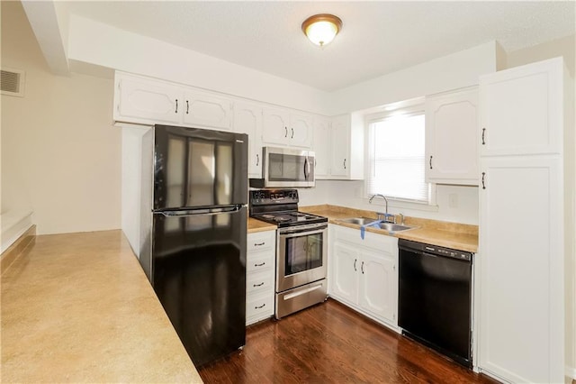 kitchen with black appliances, dark hardwood / wood-style flooring, white cabinetry, and sink