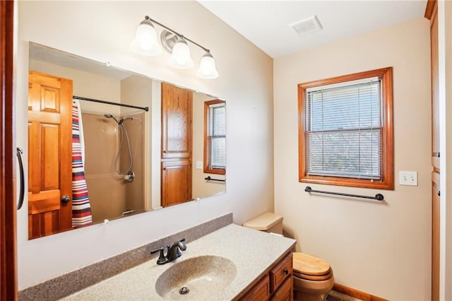 bathroom with vanity, toilet, and a shower