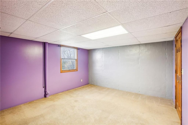 basement with light carpet and a paneled ceiling