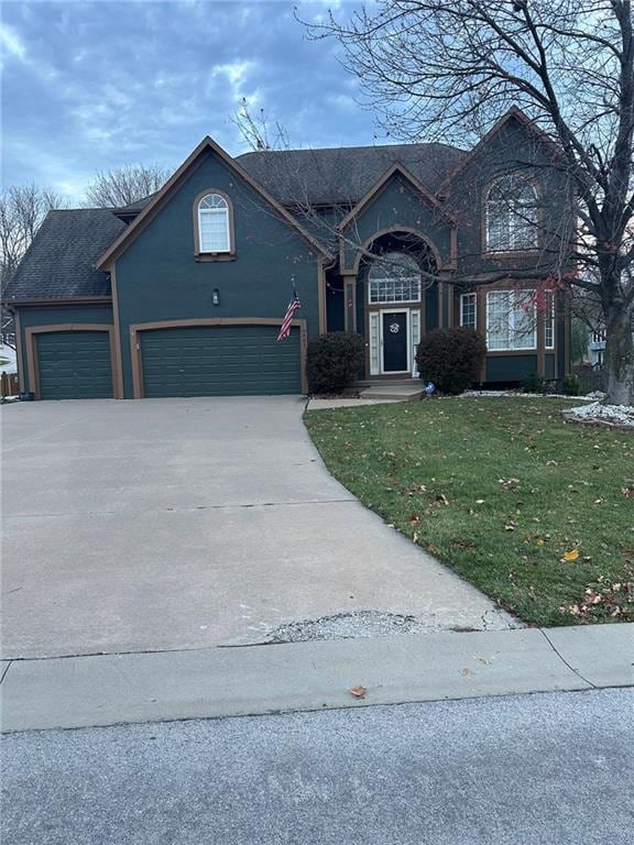 view of property with a front yard and a garage