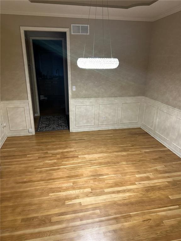 unfurnished dining area with light hardwood / wood-style flooring and crown molding