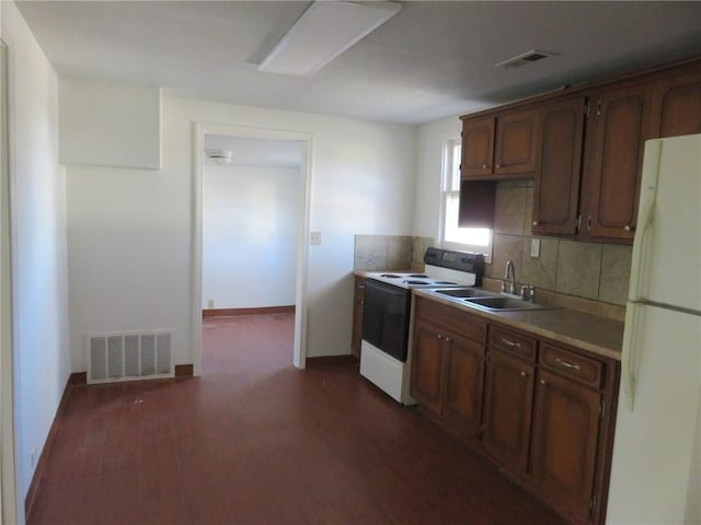 1002 S Haden St, Independence, MO 64050 - kitchen with white appliances, a sink, dark wood-style flooring, backsplash, and light countertops
