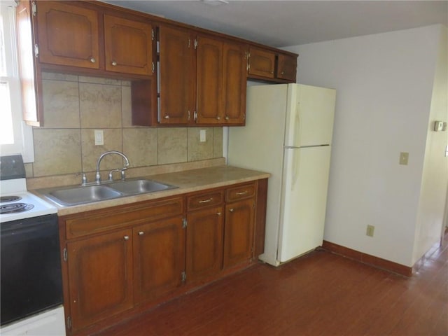 kitchen with sink, white appliances, dark wood-type flooring, and tasteful backsplash