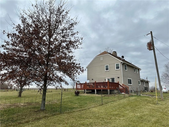 rear view of house with a wooden deck and a yard