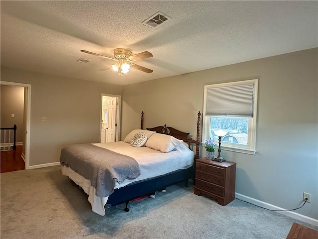 bedroom featuring a textured ceiling, ceiling fan, and light carpet