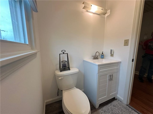 bathroom with hardwood / wood-style floors, vanity, and toilet