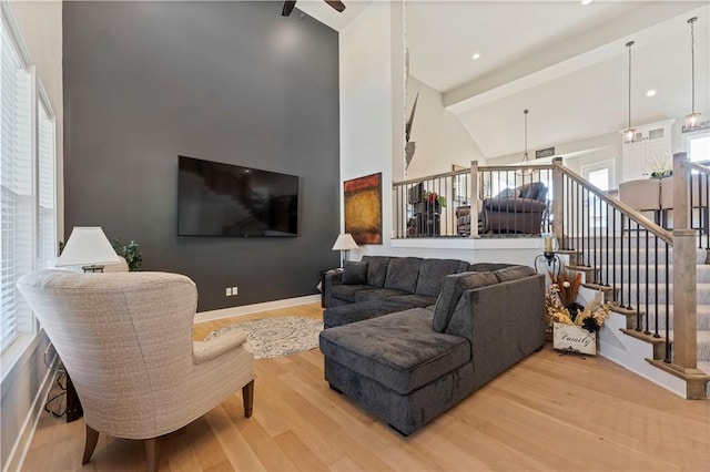 living room featuring wood-type flooring, high vaulted ceiling, and beam ceiling