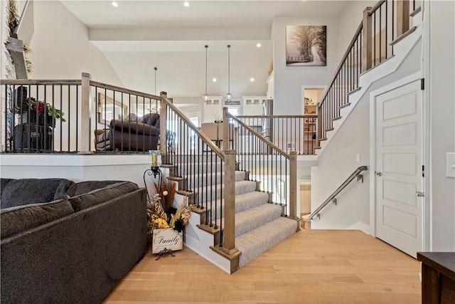 staircase featuring hardwood / wood-style floors and a towering ceiling