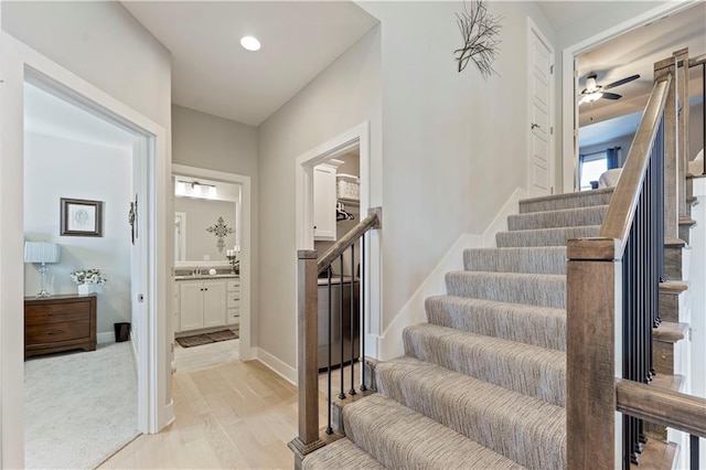 stairway with hardwood / wood-style floors and sink