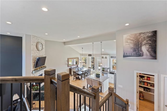 corridor with light hardwood / wood-style flooring and lofted ceiling