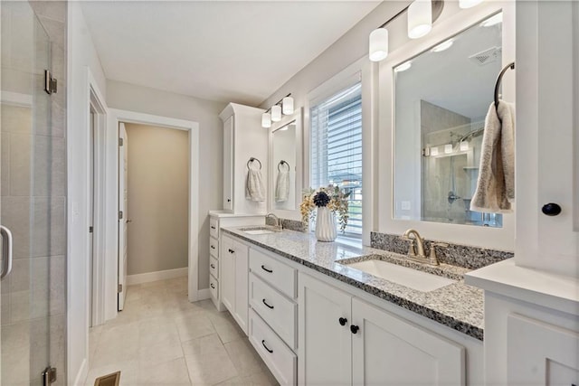 bathroom featuring tile patterned flooring, vanity, and walk in shower