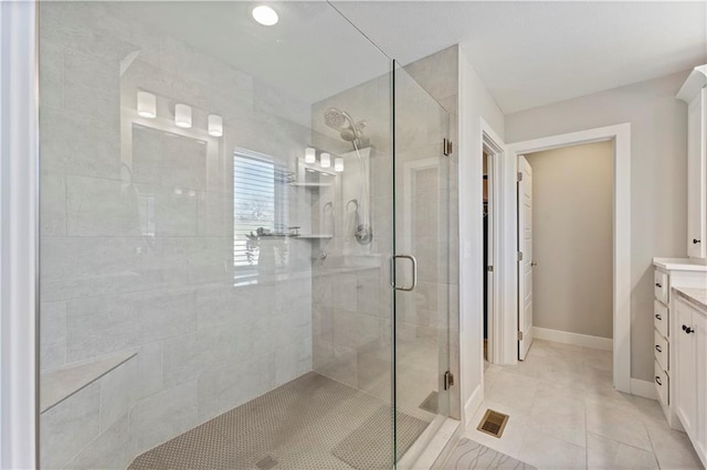 bathroom with tile patterned flooring, vanity, and an enclosed shower