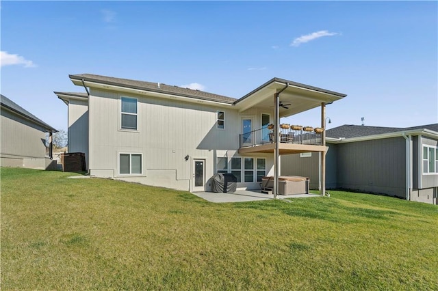 back of property featuring a lawn, a patio area, a balcony, and a hot tub