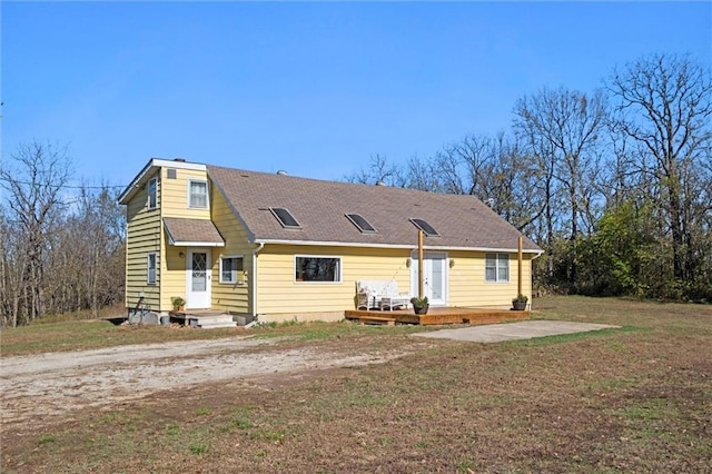 back of property featuring a yard and a wooden deck