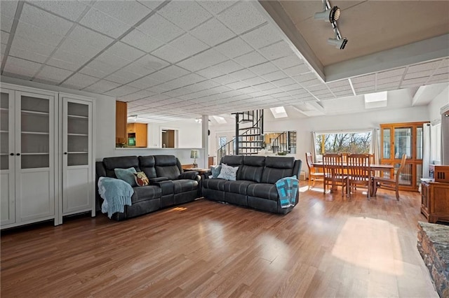 living room with hardwood / wood-style flooring and a paneled ceiling