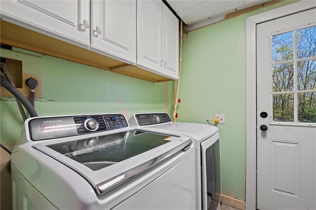 washroom with cabinets, a healthy amount of sunlight, and washing machine and dryer