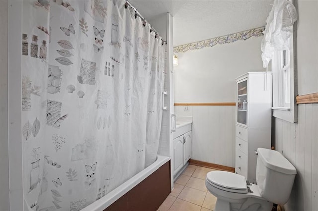 full bathroom with vanity, shower / bath combination with curtain, wooden walls, tile patterned flooring, and toilet