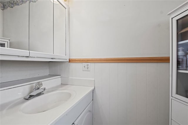 bathroom featuring wooden walls and vanity