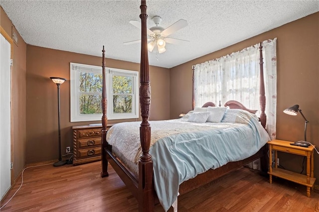 bedroom featuring hardwood / wood-style floors, a textured ceiling, and ceiling fan