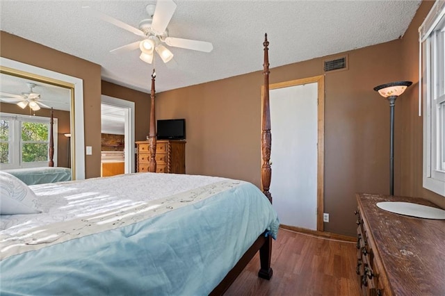 bedroom featuring a textured ceiling, dark hardwood / wood-style flooring, and ceiling fan