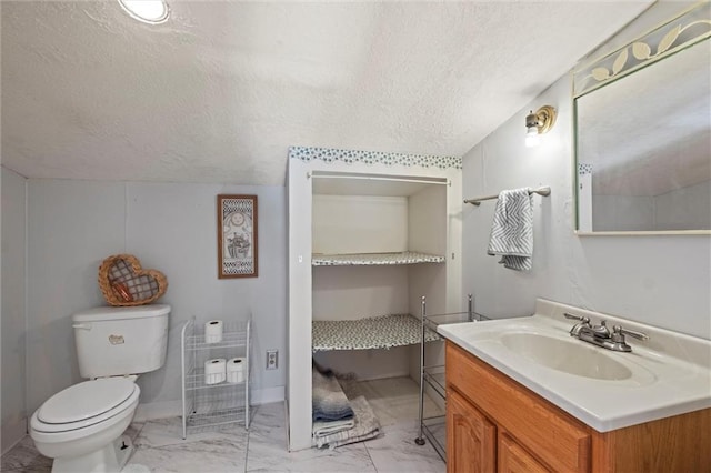 27977 W 311th St, Paola, KS 66071 - bathroom featuring a textured ceiling, marble look tile flooring, vanity, toilet, and baseboards