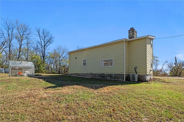 27977 W 311th St, Paola, KS 66071 - view of property exterior featuring an exterior structure, a chimney, an outbuilding, and a lawn