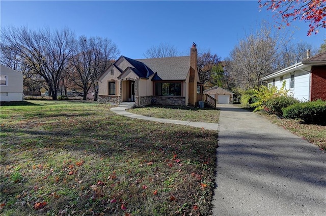 view of front facade featuring an outbuilding, a garage, and a front lawn