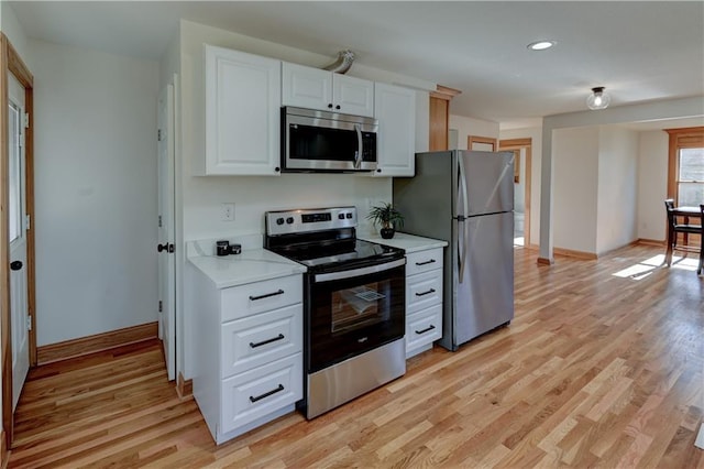 kitchen featuring appliances with stainless steel finishes, light wood-type flooring, light countertops, and white cabinetry