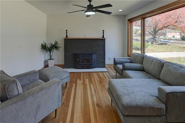 living room with ceiling fan, recessed lighting, light wood-type flooring, and baseboards