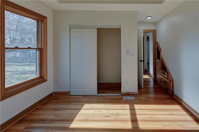 unfurnished bedroom featuring baseboards, visible vents, and light wood-style floors