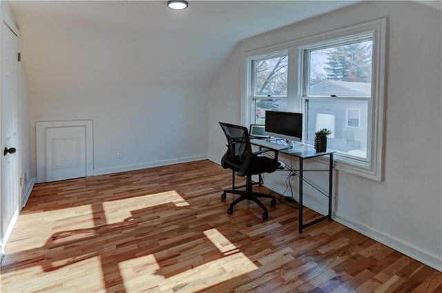 office space featuring lofted ceiling, wood finished floors, and baseboards