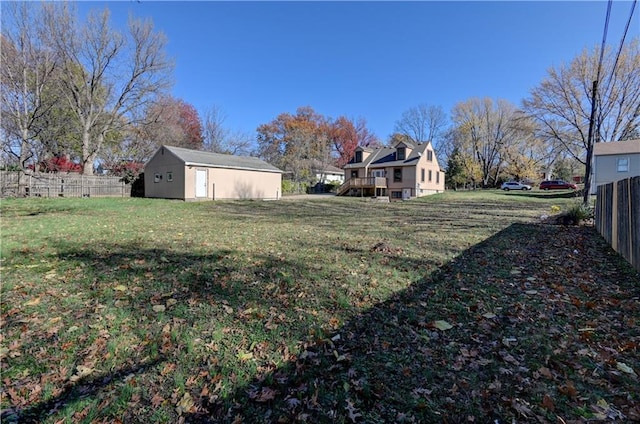 view of yard with fence and an outbuilding