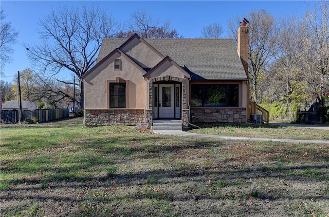 view of front of property with stone siding, a shingled roof, and cooling unit