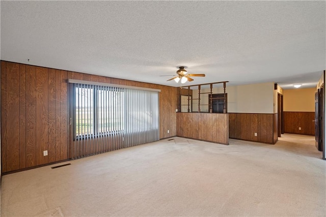 spare room with ceiling fan, light colored carpet, and a textured ceiling