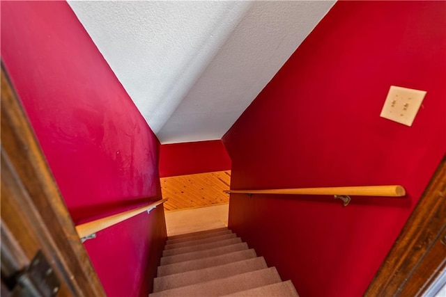 staircase with a textured ceiling