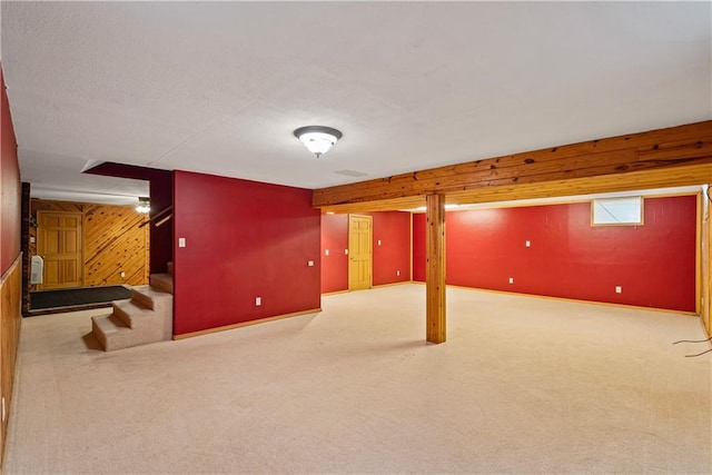 basement with light carpet and wooden walls