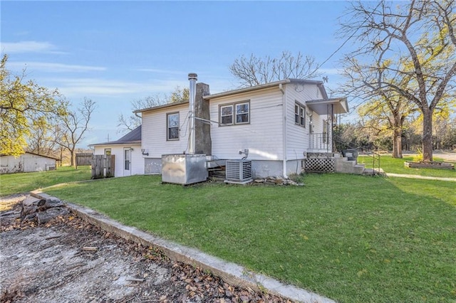 rear view of house featuring a yard and cooling unit