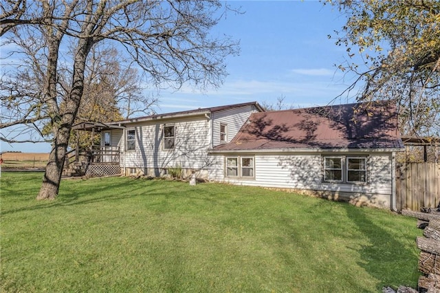 back of house featuring a wooden deck and a yard