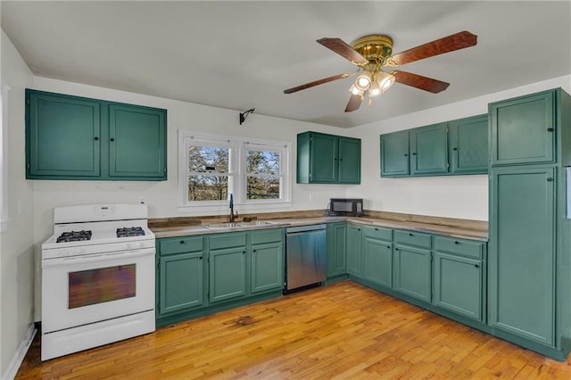 kitchen with dishwasher, white gas range, sink, and green cabinetry